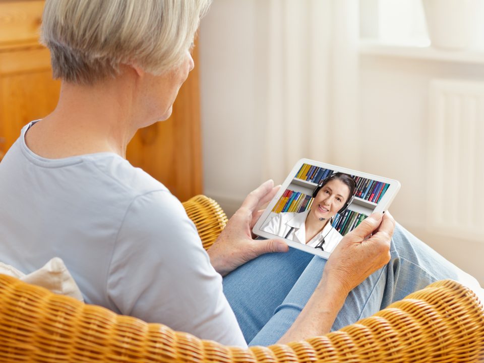 telemedicine concept, old woman with tablet pc during an online consultation with her doctor in her living room